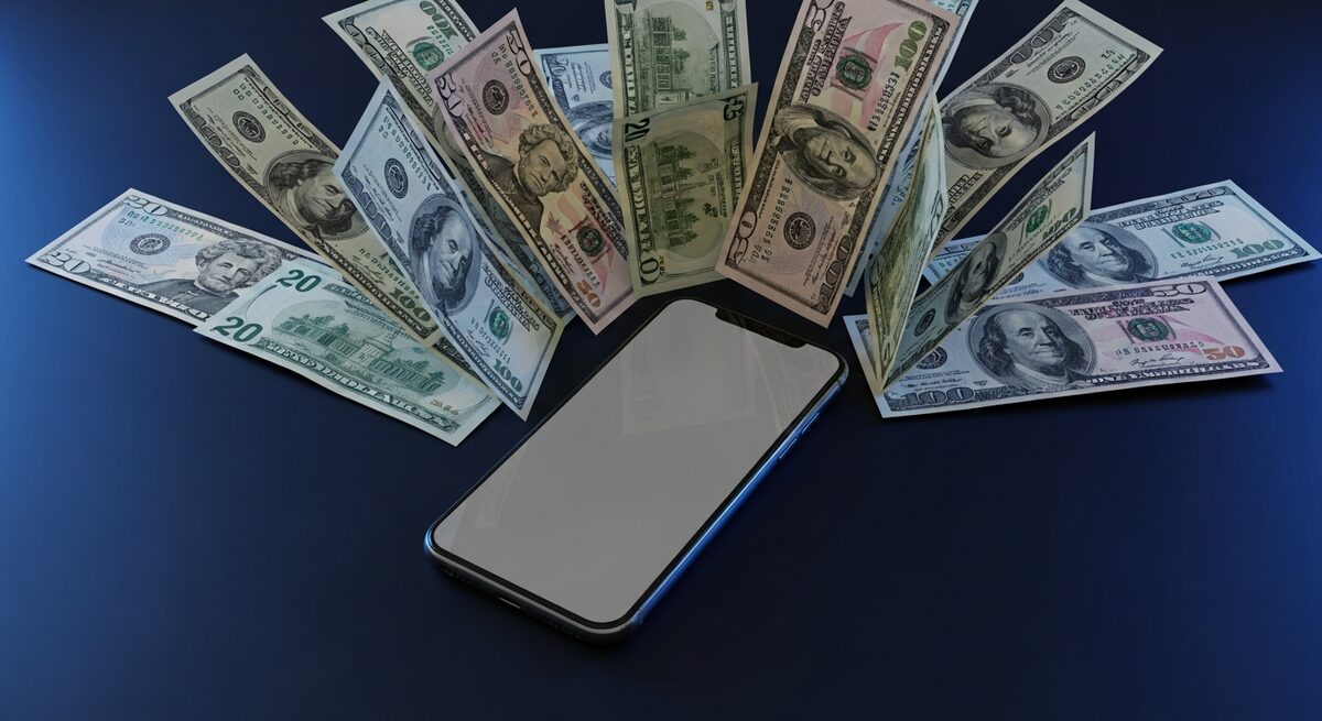 Cash and a phone illustrating an overpayment refund scam on Facebook Marketplace